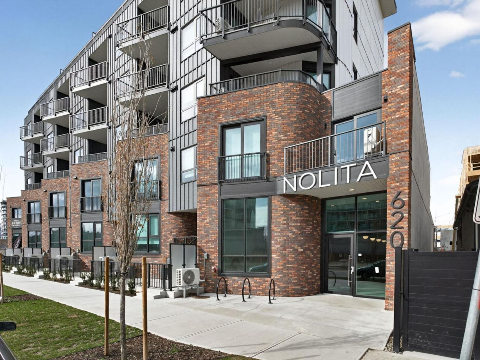 Exterior photograph of the completed Nolita residential development in downtown Kelowna, British Columbia.