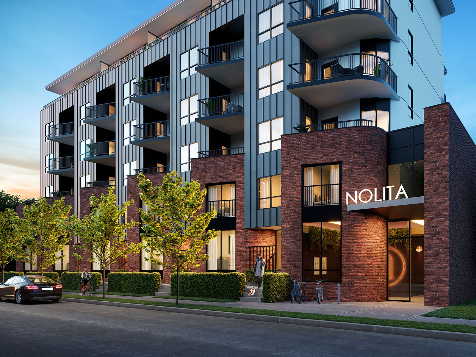nolita_exterior_dusk.jpg Dusk architectural render of Nolita in Kelowna showing the brick façade, dark metal cladding, curved balconies and illuminated entrance.